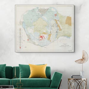 Może przedstawiać: Oprawiona, zabytkowa mapa hrabstwa Navajo w Arizonie, przedstawiająca szczegółowe badania geologiczne. Mapa przedstawia różne kolory reprezentujące różne formacje geologiczne, z tekstem na dole wskazującym tytuł i skalę mapy. Mapa jest wyświetlana na białej ścianie nad zieloną sofą.