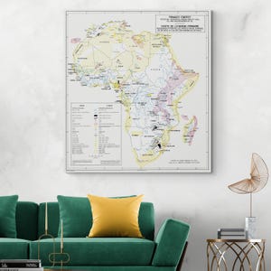 Puede incluir: Un mapa vintage enmarcado de África, etiquetado como "Primary Energy" con texto en francés. El mapa presenta ilustraciones detalladas de recursos potenciales, incluyendo carbón, petróleo y gas, con una clave y una leyenda. El mapa está en tonos beige, amarillo y varios colores.