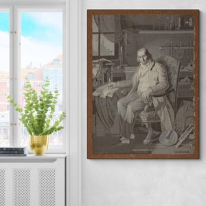 Könnte beinhalten: Ein gerahmter Sepia-Druck zeigt einen Mann, der an einem Schreibtisch sitzt und ein Zeichenwerkzeug hält. Der Druck hat einen braunen Rahmen und zeigt detaillierte Illustrationen von wissenschaftlichen Instrumenten und einem Fenster. Der Druck ist an einer weißen Wand befestigt.