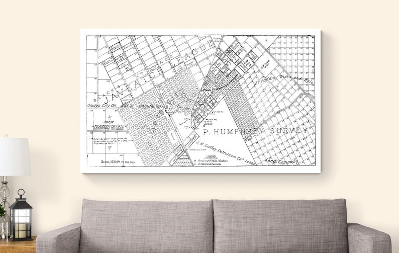 May include: Black and white vintage map print, framed in white. The map features detailed street layouts, labeled areas, and the text "P. Humphrey Survey." The map is displayed above a gray sofa.