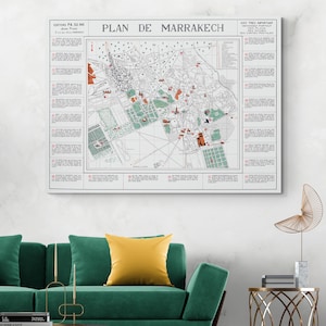 Può includere: Una mappa vintage incorniciata di Marrakech, con il titolo "PLAN DE MARRAKECH". La mappa mostra strade, edifici e aree verdi, con testo in francese. La mappa è esposta su una parete bianca sopra un divano verde.