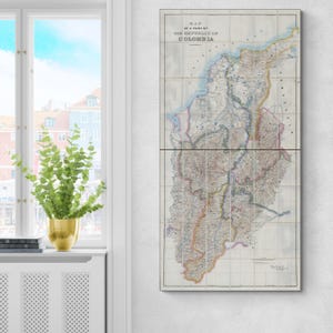 Può includere: Una mappa d'epoca della Colombia, divisa in tre pannelli, è appesa a una parete bianca. La mappa presenta informazioni geografiche dettagliate con vari colori e il titolo "MAP OF A PART OF THE REPUBLIC OF COLOMBIA".