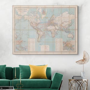 Puede incluir: Un mapa del mundo vintage enmarcado, con un océano azul claro y continentes beige. El mapa presenta información geográfica detallada y está enmarcado en un borde de tonos neutros. El título "PLANISPHERE CELESTE" es visible. El mapa está sobre un sofá verde.