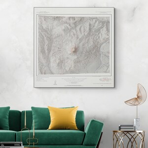 Puede incluir: Un mapa topográfico en blanco y negro de una región montañosa. El mapa muestra curvas de nivel, ríos y otras características geográficas. El mapa está enmarcado y colgado en una pared blanca.