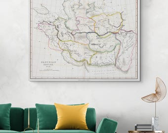 Pode incluir: Um mapa antigo emoldurado do Império Parta, com contornos geográficos e texto detalhados. O mapa usa tons de bege, verde, amarelo e rosa. O título "PARTHIAN EMPIRE" é visível na parte inferior. O mapa está acima de um sofá verde com almofadas amarelas.