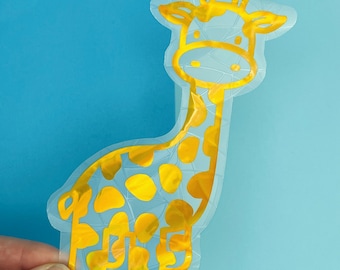 May include: A gold iridescent giraffe sticker with a simple design. The sticker is on a blue background.