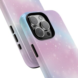 May include: A pink and blue galaxy phone case with a black camera bump and a white starry design.