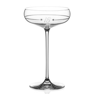 May include: A clear glass champagne flute with a thin stem and a wide bowl. The bowl has a delicate etched design and the number "18" is etched on the side.