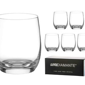 May include: Set of six clear glass tumblers with a rounded shape. The glasses are made of fine lead-free crystal and are packaged in a black box with the text "Diamante Fine Lead Free Crystal".