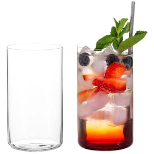 Op de afbeelding: Twee heldere, cilindrische drinkglazen. Eén is leeg, de andere gevuld met een kleurrijke cocktail. De cocktail bevat ijs, aardbeien, bosbessen en munt, met een roestvrijstalen rietje.