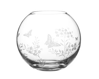 May include: A clear glass bowl with an etched design of butterflies and flowers. The bowl is round and has a wide opening.
