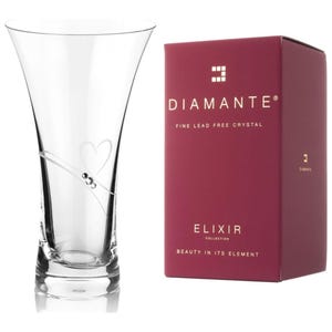 Op de afbeelding: Een heldere glazen vaas met een hartvormig ontwerp en een zilveren lint. De vaas maakt deel uit van de Diamante Elixir Collection, die is gemaakt van fijn loodvrij kristal.