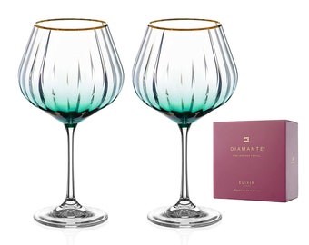 May include: Two green and gold-rimmed stemmed glasses with a ribbed design. The glasses are on a white background with a pink box that says "Diamante" and "Elixir" on it.