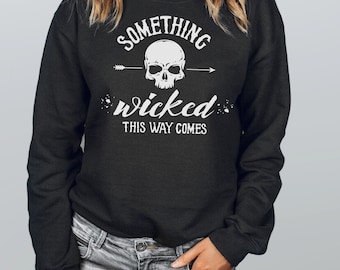 May include: Black sweatshirt with a white skull and crossbones graphic and the text "Something wicked this way comes."