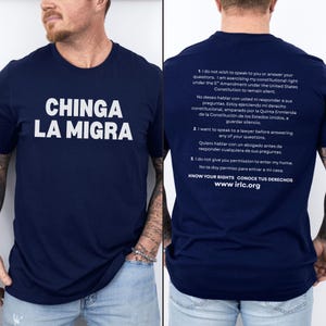 May include: Navy blue t-shirt with the phrase "CHINGA LA MIGRA" in white block letters. The back of the shirt has text in English and Spanish about constitutional rights. The website www.irlc.org is also printed on the back.