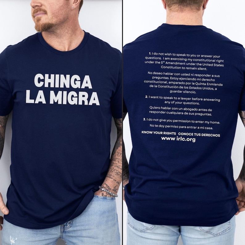 May include: Navy blue t-shirt with the phrase "CHINGA LA MIGRA" in white block letters. The back of the shirt has text in English and Spanish about constitutional rights. The website www.irlc.org is also printed on the back.