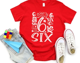 May include: Red short-sleeved t-shirt with a white graphic design featuring the number six and the word "six" repeated in different styles. The shirt is laying flat on a white background.