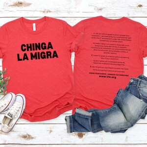 May include: Red t-shirts with black text. One shirt reads "CHINGA LA MIGRA." The other shirt has text about constitutional rights in English and Spanish. White sneakers and blue jeans are also in the image.
