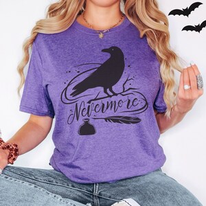 May include: Purple t-shirt with a black raven silhouette, a quill, and an ink bottle. The text "Nevermore" is written in a cursive font.