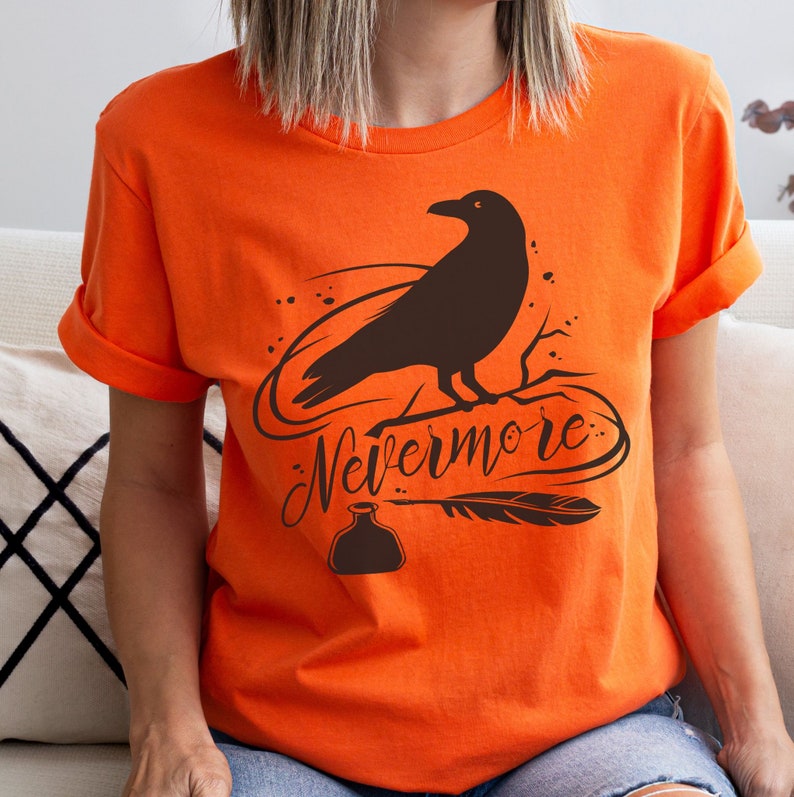 May include: Orange t-shirt with a black raven silhouette, a quill pen, and an ink bottle. The text "Nevermore" is written in a stylized font.