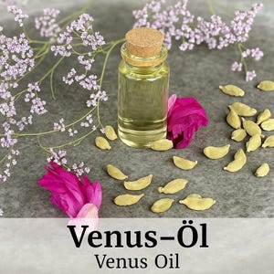 May include: A clear glass bottle with a cork stopper filled with a light yellow liquid. The bottle is surrounded by small, light green cardamom pods and pink flower petals on a grey surface. The text "Venus-Öl Venus Oil" is displayed below the image.