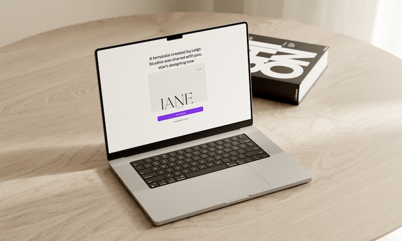 May include: A laptop computer open to a website with the text "A template created by Leigh Studios was shared with you. Start designing now." and a purple button that says "Get Started". The website also features the text "IANE." in a white box.
