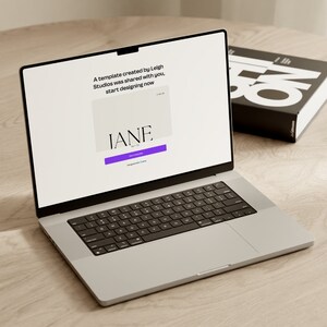 May include: A laptop computer open to a website with the text "A template created by Leigh Studios was shared with you. Start designing now." and a purple button that says "Get Started". The website also features the text "IANE." in a white box.