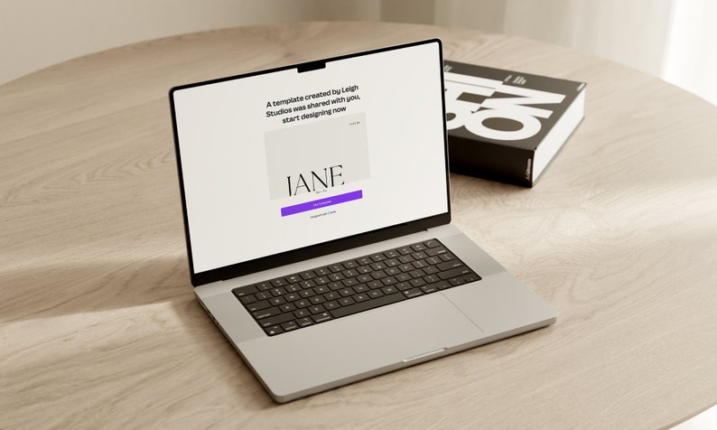May include: A laptop computer open to a website with the text "A template created by Leigh Studios was shared with you. Start designing now." and a purple button that says "Get Started". The website also features the text "IANE." in a white box.