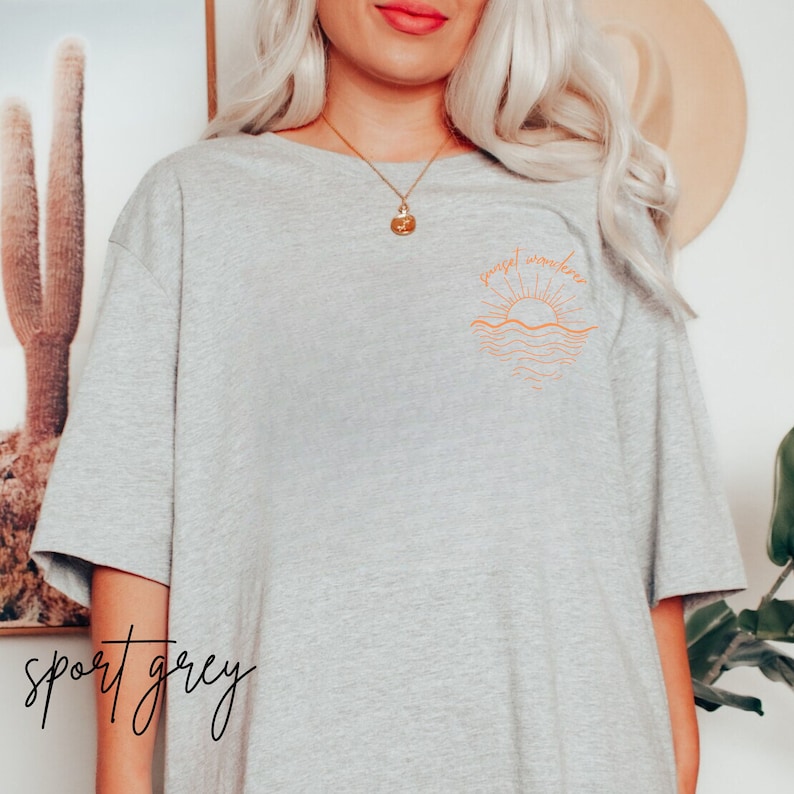 May include: A heather grey t-shirt with a graphic of a sunset over the ocean and the text "sunset somewhere".