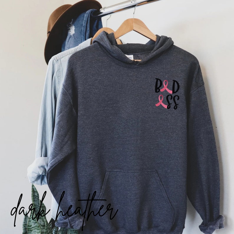 May include: Dark heather grey hooded sweatshirt with a pink ribbon and the text "B&D" on the front.