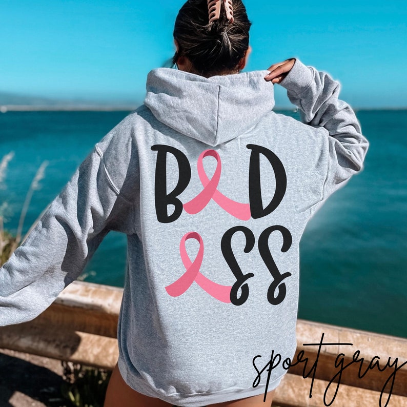May include: A gray hoodie with a black and pink graphic that says "BADASS" with a pink ribbon. The hoodie is a sport gray color.