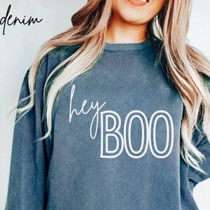 May include: A dark blue sweatshirt with the text "hey BOO" in white outlined letters.