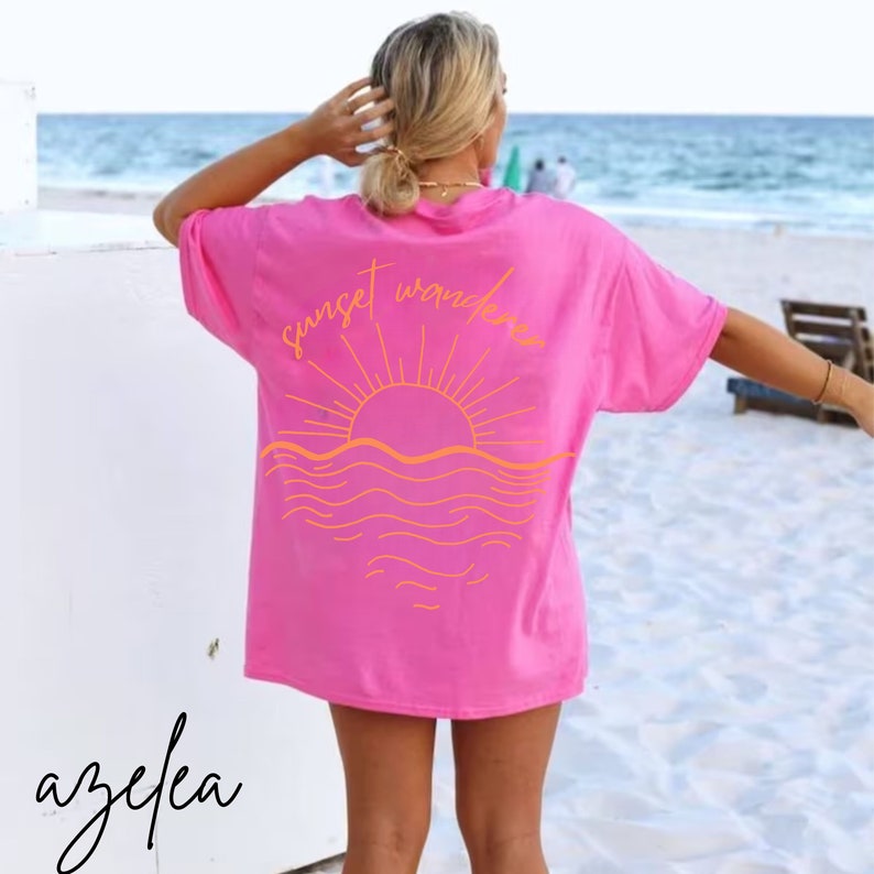 May include: Pink t-shirt with a sunset and waves graphic and the text "sunset wanderer" on the back.