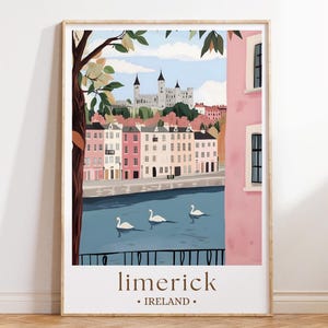 May include: A framed art print featuring a scenic view of Limerick, Ireland. The illustration depicts a river with three swans, colorful buildings, and a castle in the background. The print includes the text "limerick • IRELAND."
