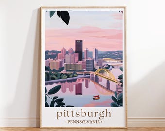 May include: A framed art print of Pittsburgh, Pennsylvania, featuring a cityscape with a yellow bridge, buildings, and a river. The artwork has a soft color palette of pink, blue, and green, with the word "pittsburgh" at the bottom.