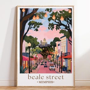 Pode incluir: Uma impressão artística emoldurada de Beale Street em Memphis, Tennessee. A ilustração retrata uma cena de rua com edifícios, carros e luzes de corda sob um céu rosa e azul. As palavras "beale street" e "memphis" são impressas na parte inferior.