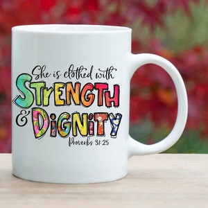 May include: Two white ceramic mugs with a colorful design that says "She is clothed with STRENGTH & DIGNITY Proverbs 31:25".