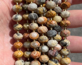 Op de afbeelding: Een meerstrengs ketting met facetgeslepen, ronde kralen in beige, bruin, grijs en oranje tinten. De kralen zijn geregen op goudkleurig draad, waardoor een textuurrijk en kleurrijk accessoire ontstaat.