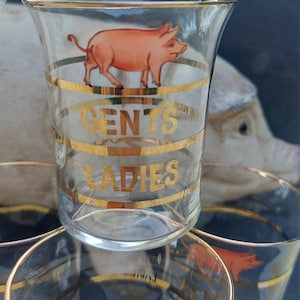A set of six vintage shot glasses. These novelty glasses are delightful, the shot measures are marked with gilded rims and pink pigs.
