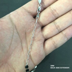 May include: A silver chain with a 5mm back side extender. The chain is made of small, oval-shaped links.