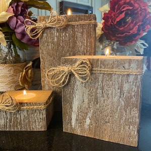 Puede incluir: Tres portavelas de madera r&uacute;stica con un acabado blanco desgastado. Cada portavelas tiene un lazo de cuerda natural y est&aacute; dise&ntilde;ado para sostener una vela de t&eacute;.