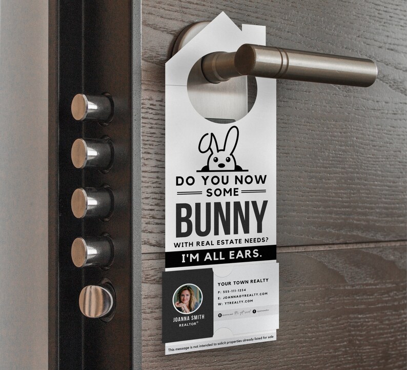 Op de afbeelding: Een witte deurhanger met een konijnenillustratie en de tekst "Do you now some bunny with real estate needs? I'm all ears."  De deurhanger bevat ook een visitekaartje met de naam Joanna Smith, makelaar en de contactgegevens van Your Town Realty.