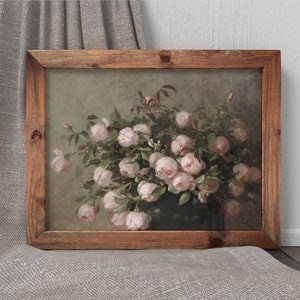 May include: A framed floral print featuring a bouquet of pink roses in a dark vase. The artwork has a vintage aesthetic, with a wooden frame and a soft, muted color palette. The roses are in full bloom, with green leaves.