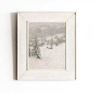 May include: A framed winter landscape painting. The artwork depicts a snowy scene with trees and a figure in the distance. The frame is white, and the overall aesthetic is vintage and serene.