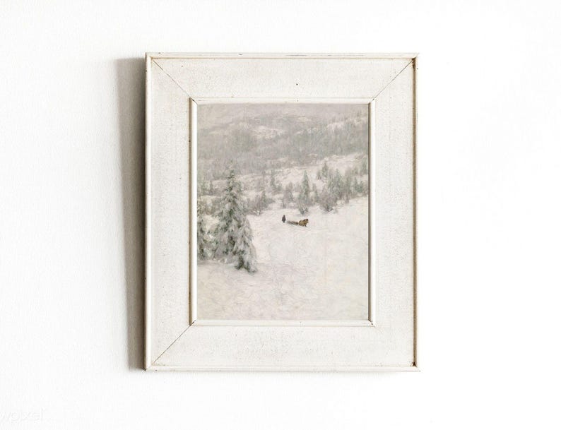 May include: A framed winter landscape painting. The artwork depicts a snowy scene with trees and a figure in the distance. The frame is white, and the overall aesthetic is vintage and serene.