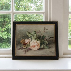 May include: A framed watercolor painting of a bouquet of pink roses with green leaves and stems. The roses are arranged on a light gray background.