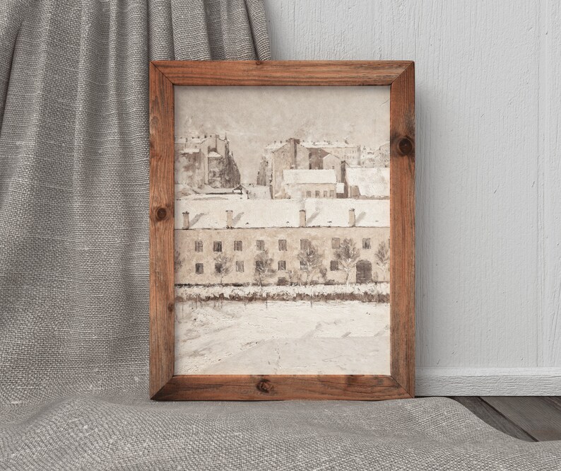 May include: A framed watercolor painting of a snowy cityscape with brown buildings and trees. The painting is in a rustic wooden frame.