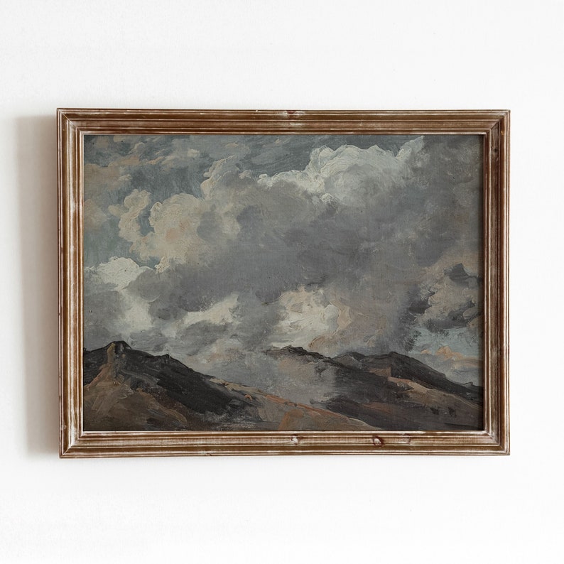 May include: A framed painting depicting a landscape with a cloudy sky and rolling hills. The painting is done in a muted palette of browns, greys, and blues.