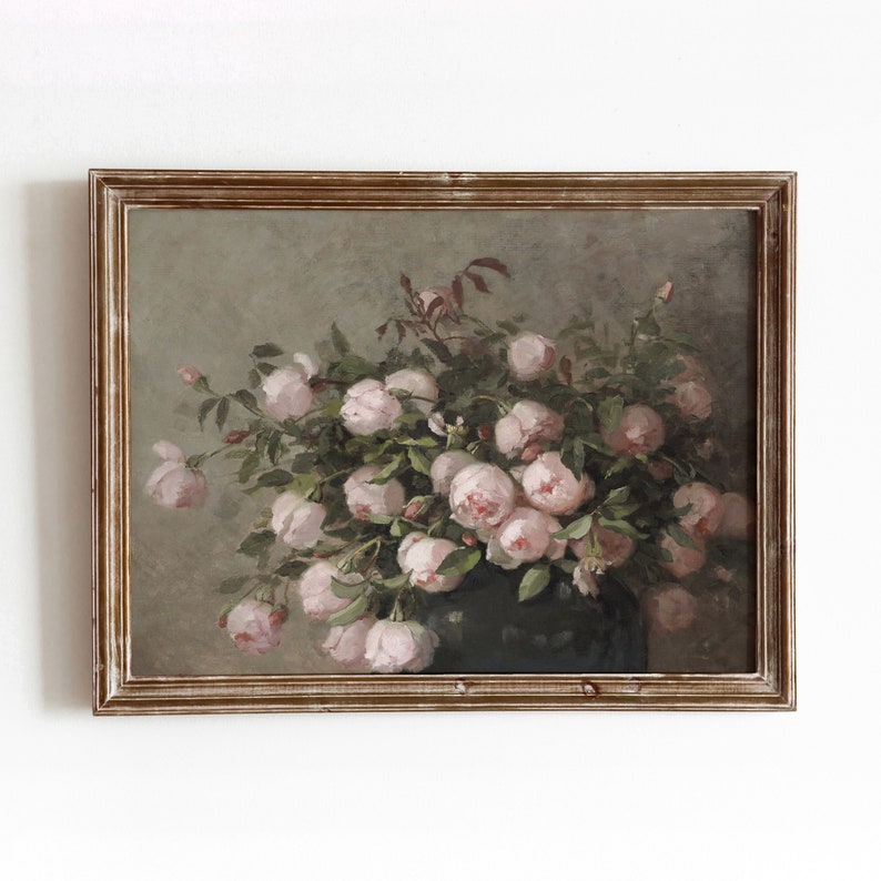 May include: An antique-style framed painting featuring a lush bouquet of pink roses. The roses are in full bloom, surrounded by green foliage, and set against a muted green background. The frame is a distressed gold color.