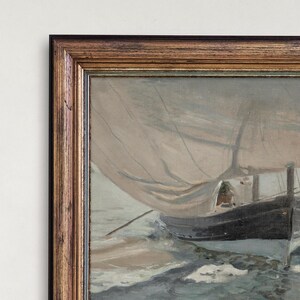 May include: A framed painting of a sailboat with white sails and a dark hull, sailing on a choppy sea with whitecaps. The painting is in a brown wooden frame with a gold trim.